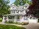Attractive two-story home with a grand front porch, lush landscaping, and an attached garage at 1702 Mcrae Pl, Hillsborough, NC 27278