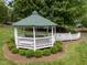 Picturesque gazebo with green roof, surrounded by a circular garden, offering a serene outdoor retreat at 1702 Mcrae Pl, Hillsborough, NC 27278