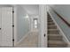 Hallway with carpet flooring, multiple doors, and a staircase leading to another floor at 1702 Mcrae Pl, Hillsborough, NC 27278