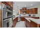 Gourmet kitchen with stainless steel appliances, custom cabinets, and a seamless countertop at 1702 Mcrae Pl, Hillsborough, NC 27278