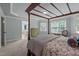 Bright main bedroom featuring a four poster bed, plush carpet, and large windows overlooking the yard at 1702 Mcrae Pl, Hillsborough, NC 27278
