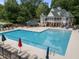 Expansive pool with lounge chairs and umbrellas, adjacent to a large pool house, enhancing outdoor leisure at 1702 Mcrae Pl, Hillsborough, NC 27278