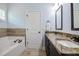Elegant bathroom with a soaking tub, double vanity with granite countertops, and tile flooring at 18 Heathgreen Dr, Clayton, NC 27527