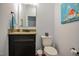 Well-lit half bathroom featuring dark cabinetry, granite counters, and a decorative mirror at 18 Heathgreen Dr, Clayton, NC 27527