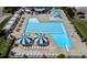 Aerial view of a community pool with multiple swimming areas, lounge chairs, and umbrellas at 18 Heathgreen Dr, Clayton, NC 27527