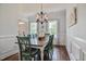 A formal dining room with a chandelier, wainscoting, hardwood floors, and lots of natural light at 18 Heathgreen Dr, Clayton, NC 27527