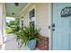 Cozy porch view features a light-blue door, brick accents, and potted plants at 18 Heathgreen Dr, Clayton, NC 27527