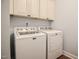 Laundry room with a washer and dryer with white cabinets for storage at 18 Heathgreen Dr, Clayton, NC 27527