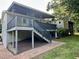 A backyard featuring an elevated porch with stairs leading down to a brick pathway, and verdant lawn at 197 Country Routt Brown Rd, Pittsboro, NC 27312