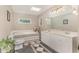Bright bathroom with a skylight, soaking tub, and double vanity with marble counters and patterned tile floor at 197 Country Routt Brown Rd, Pittsboro, NC 27312