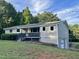 Charming ranch home with a covered porch, gray siding, green yard and mature trees at 197 Country Routt Brown Rd, Pittsboro, NC 27312