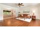 Sunlit living room featuring hardwood floors, a comfortable leather sofa, and a dining area in the background at 197 Country Routt Brown Rd, Pittsboro, NC 27312