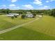 Scenic aerial view highlighting the property's pond, outbuildings, lush lawns, and inviting main residence at 1993 Lucy Garrett Rd, Roxboro, NC 27574