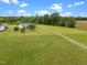 Picturesque aerial view featuring a large grassy yard, a home, long driveway, and surrounding trees at 1993 Lucy Garrett Rd, Roxboro, NC 27574