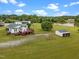 Aerial view of estate showcasing the home, surrounding greenery, outbuildings, and a picturesque pond at 1993 Lucy Garrett Rd, Roxboro, NC 27574