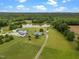 Picturesque aerial view of a sprawling estate with multiple buildings, a serene pond, and verdant fields at 1993 Lucy Garrett Rd, Roxboro, NC 27574
