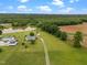 Beautiful aerial view showcasing the property's pond, outbuildings, lush greenery, and a charming residence at 1993 Lucy Garrett Rd, Roxboro, NC 27574
