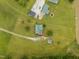 Aerial view of house, barn, and pond, highlighting the vast green space and idyllic setting at 1993 Lucy Garrett Rd, Roxboro, NC 27574