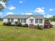 Inviting single-story home with a well-manicured lawn, white siding, and accents of green at 1993 Lucy Garrett Rd, Roxboro, NC 27574