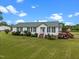 Charming single-story home featuring green shutters, mature landscaping, and a welcoming front lawn at 1993 Lucy Garrett Rd, Roxboro, NC 27574