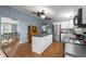 Open kitchen featuring white cabinets, an island, stainless steel appliances, and wood-look floors at 1993 Lucy Garrett Rd, Roxboro, NC 27574