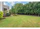 Lush green backyard with mature trees, landscaping, and a charming fence providing privacy and a park-like setting at 200 Vintage Hill Cir, Apex, NC 27539