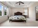 This comfortable bedroom features large windows that let in natural light and a tray ceiling with a fan at 200 Vintage Hill Cir, Apex, NC 27539
