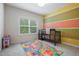 A cozy bedroom with a playful color scheme and a window overlooking the backyard at 200 Vintage Hill Cir, Apex, NC 27539