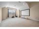 Spacious room with a large screen, chandelier and big window, ideal for movie nights and recreation at 200 Vintage Hill Cir, Apex, NC 27539