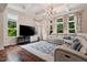 Bright living room boasts hardwood floors, coffered ceiling, large windows, and a stylish area rug at 200 Vintage Hill Cir, Apex, NC 27539
