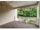 Covered back porch with string lights, white railings, and view of trees, for outdoor entertaining and relaxation at 200 Vintage Hill Cir, Apex, NC 27539