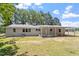 Rear view of the home showing the metal roof, covered patio, and brick exterior paint at 2003 Broadway Rd, Sanford, NC 27332