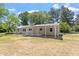 View of the back of home with a covered patio and metal roof on a bright sunny day at 2003 Broadway Rd, Sanford, NC 27332