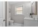 Half bathroom featuring a marble tiled floor, painted walls, window, vanity, and modern toilet at 2003 Broadway Rd, Sanford, NC 27332