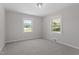 Bright bedroom features neutral walls, plush carpet, a modern light fixture, and great natural light at 2003 Broadway Rd, Sanford, NC 27332