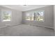 Neutral bedroom featuring plush gray carpet, a ceiling light fixture, and natural light from three picture windows at 2003 Broadway Rd, Sanford, NC 27332