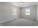 Bright bedroom features neutral walls, plush carpet, a modern light fixture, and two windows at 2003 Broadway Rd, Sanford, NC 27332