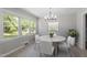 Bright dining room features a round table, white chairs, modern lighting, and large windows at 2003 Broadway Rd, Sanford, NC 27332