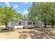 Recently renovated home with manicured landscaping and mature trees on a lush green lawn at 2003 Broadway Rd, Sanford, NC 27332