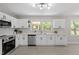 Bright kitchen featuring white cabinets, stainless steel appliances, and a large window over the sink area at 2003 Broadway Rd, Sanford, NC 27332
