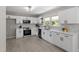 Modern white kitchen featuring sleek appliances, ample cabinets, a bright window, and stylish countertops at 2003 Broadway Rd, Sanford, NC 27332