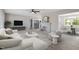 Sun-filled living room with a fireplace, white furniture, modern ceiling fan, and light wood-look floors at 2003 Broadway Rd, Sanford, NC 27332