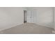 A bedroom with neutral carpet, a closet, and a view into another room at 208 Essex Rd, Nashville, NC 27856