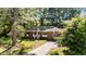 Charming single story brick home featuring a bright red door and mature trees at 208 Essex Rd, Nashville, NC 27856