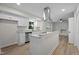 Bright kitchen featuring granite countertops, stainless appliances, island, and modern vent hood at 208 Essex Rd, Nashville, NC 27856