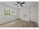A living room featuring hardwood floors, a brick fireplace, and two bright windows at 208 Essex Rd, Nashville, NC 27856