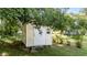 A backyard storage shed with a door and small window, sheltered by trees at 208 Essex Rd, Nashville, NC 27856
