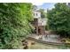 An inviting backyard with a fire pit and a patio beneath a screened porch, surrounded by mature trees at 2236 The Cir, Raleigh, NC 27608