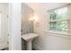 Charming powder room featuring a pedestal sink and a window with a view at 2236 The Cir, Raleigh, NC 27608