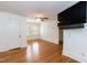 Bright bedroom featuring wood flooring, a ceiling fan, and a large mounted TV at 2236 The Cir, Raleigh, NC 27608